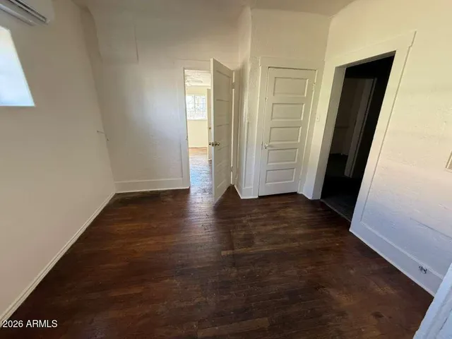 an empty room with wooden floor and entrance