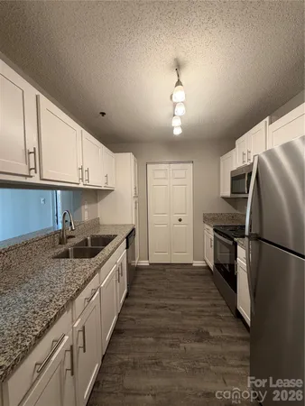 a kitchen with granite countertop kitchen island wooden cabinets and stainless steel appliances