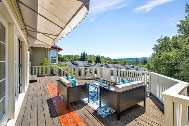 a view of a balcony with wooden floor and outdoor seating