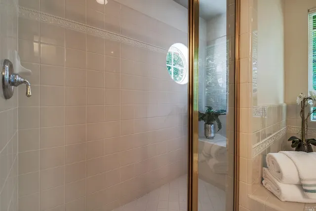 a bathroom with a tub double sink window and mirror