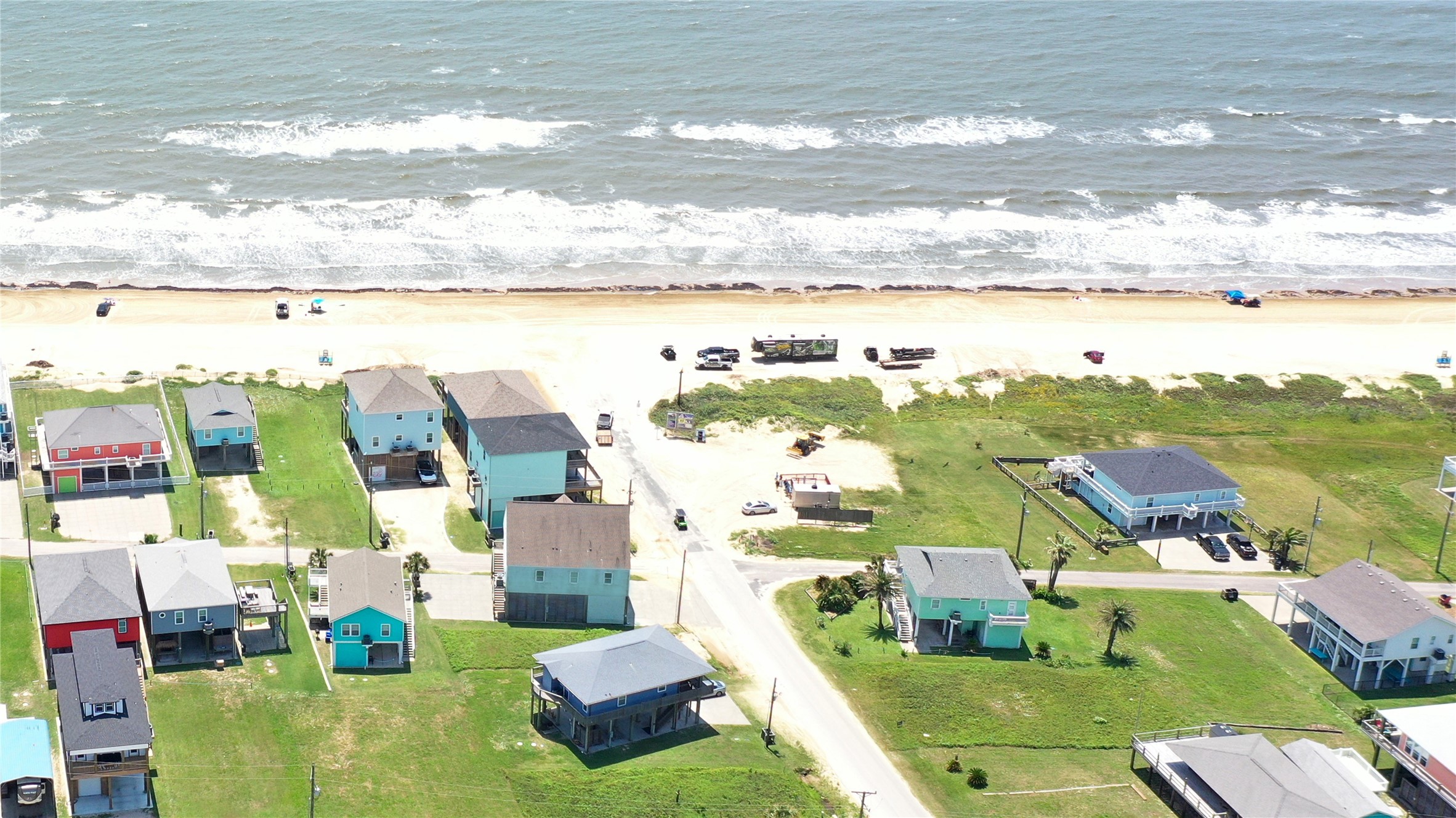 0 Crystal Beach Road Crystal Beach, TX 77650 - Photo 9 of 18 This aerial photo showcases a beachfront neighborhood with colorful homes and direct access to a sandy beach. Ideal for those seeking a coastal lifestyle, the area offers scenic ocean views and a relaxed atmosphere.