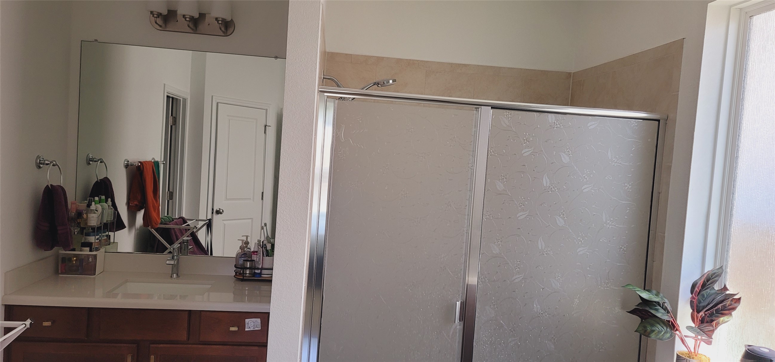 716 Leeward Pass Leander, TX 78641 - Photo 13 of 26 A well-appointed bathroom features a spacious shower and a wide vanity with ample counter space.