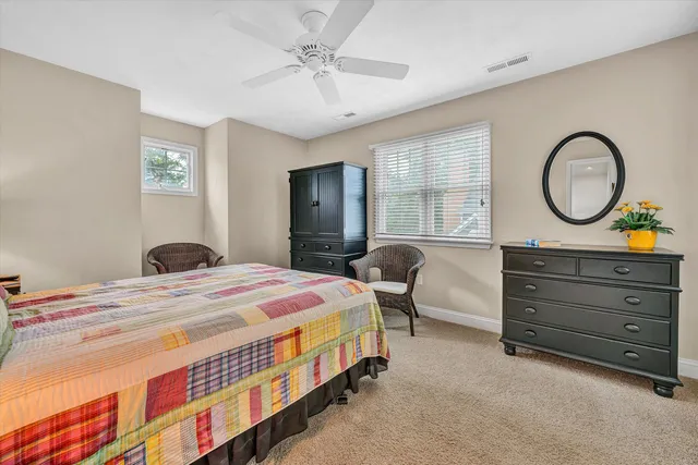 a bedroom with a bed and a lamp on dresser