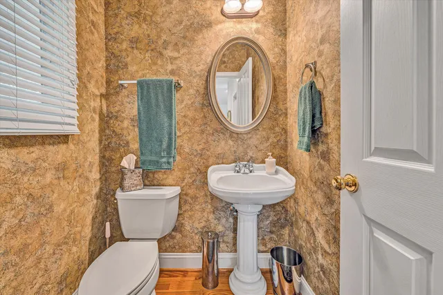 a bathroom with a toilet sink and mirror