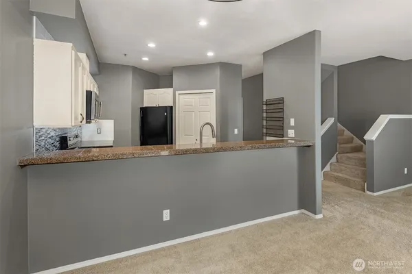 a kitchen with a stove refrigerator and mirror