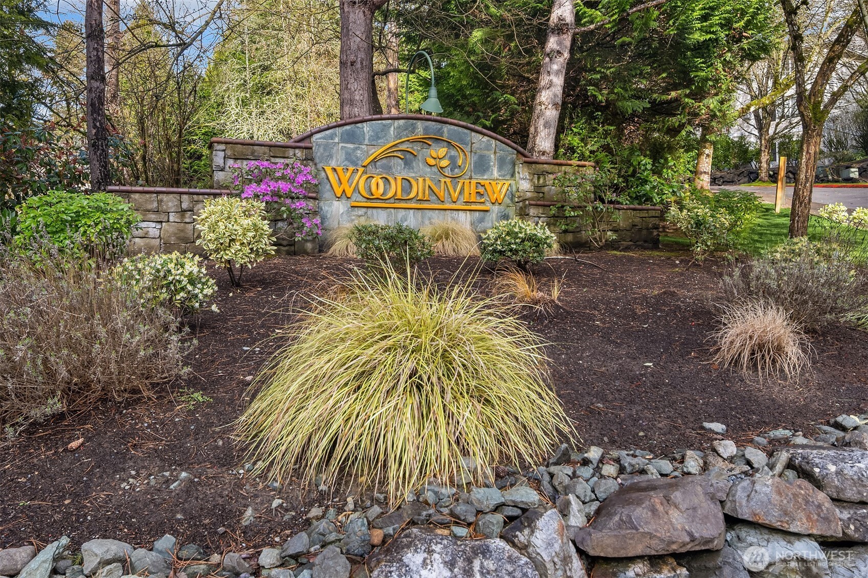 12113 Northeast 172nd Place, Unit J202 Bothell, WA 98011 - Photo 29 of 29 a blue sign that is sitting in front of flowers