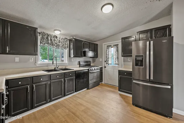 a kitchen with a refrigerator stove sink and microwave