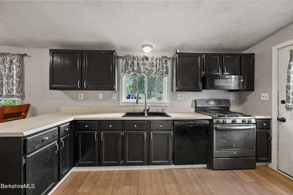 a kitchen with a sink stove top oven and cabinets