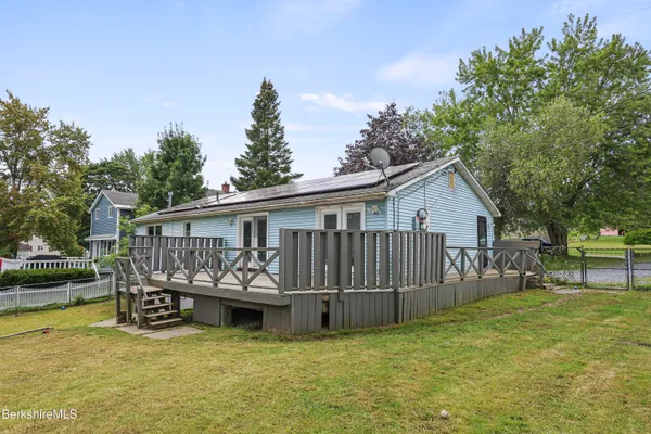 a view of a house with pool and a yard
