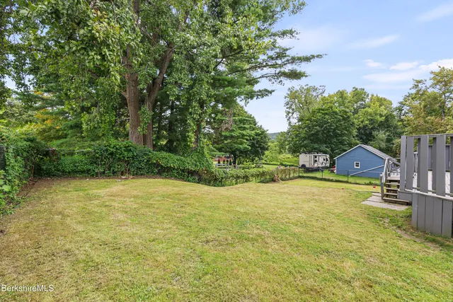 a front view of a house with yard and swimming pool