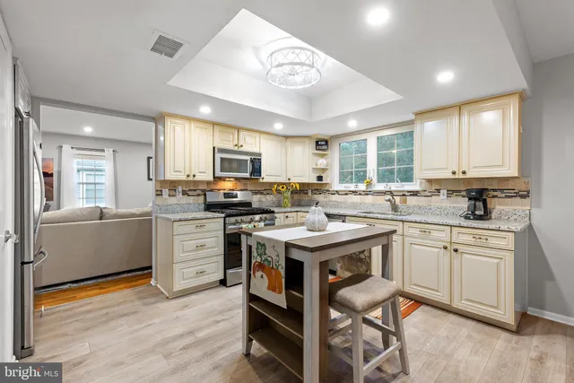 a kitchen with granite countertop a sink appliances cabinets and furniture