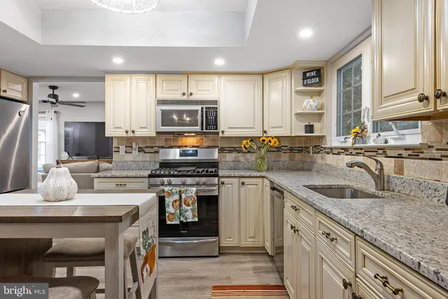 a kitchen with stainless steel appliances granite countertop a sink stove and refrigerator