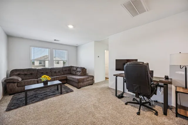 a living room with furniture and a piano