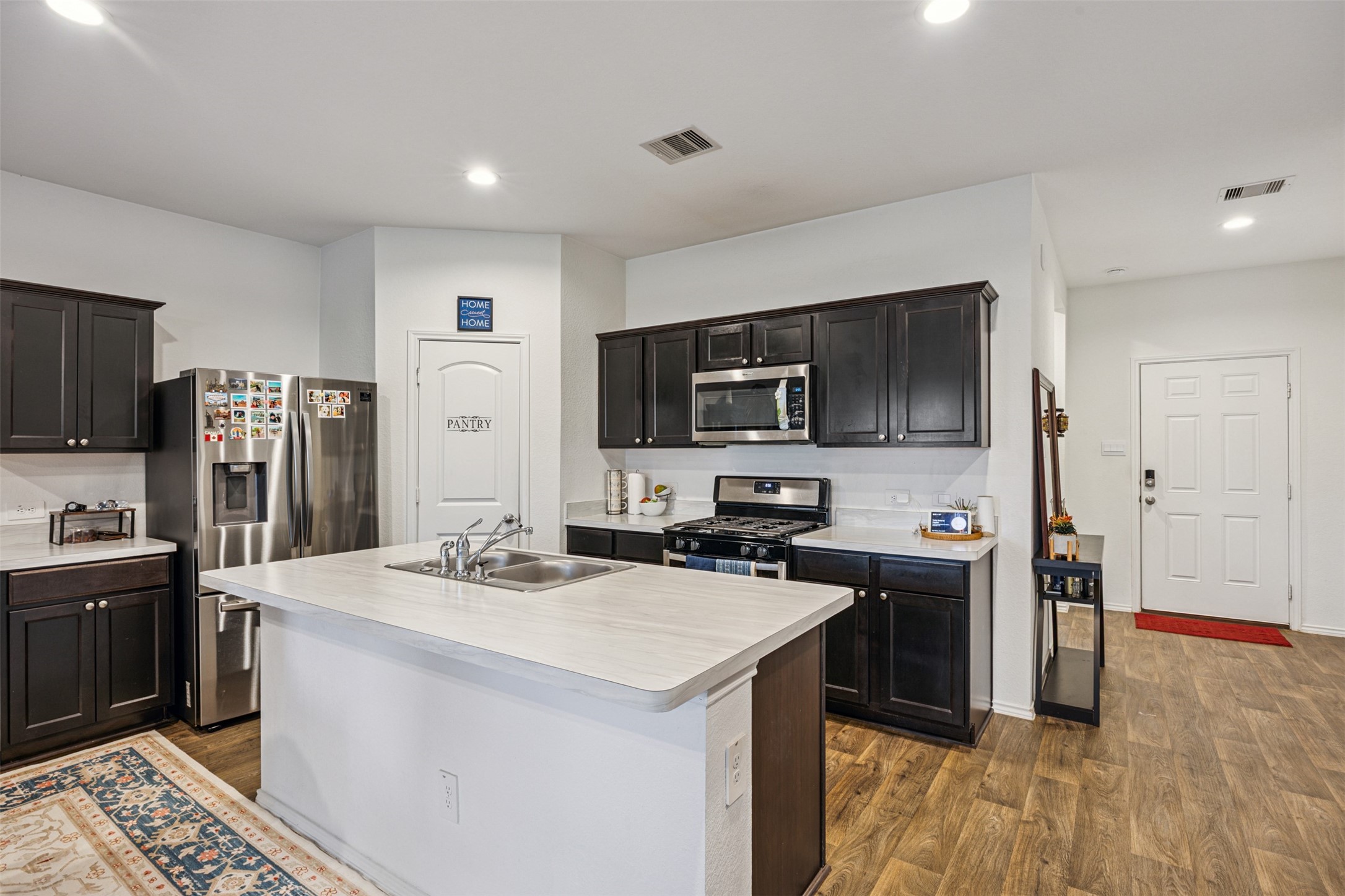 5102 Hedgerose Lane Katy, TX 77449 - Photo 7 of 31 a kitchen with a sink a stove cabinets and stainless steel appliances