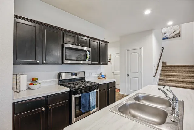 a kitchen with stainless steel appliances granite countertop a sink stove and microwave