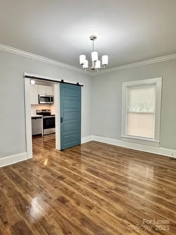 a view of empty room with wooden floor