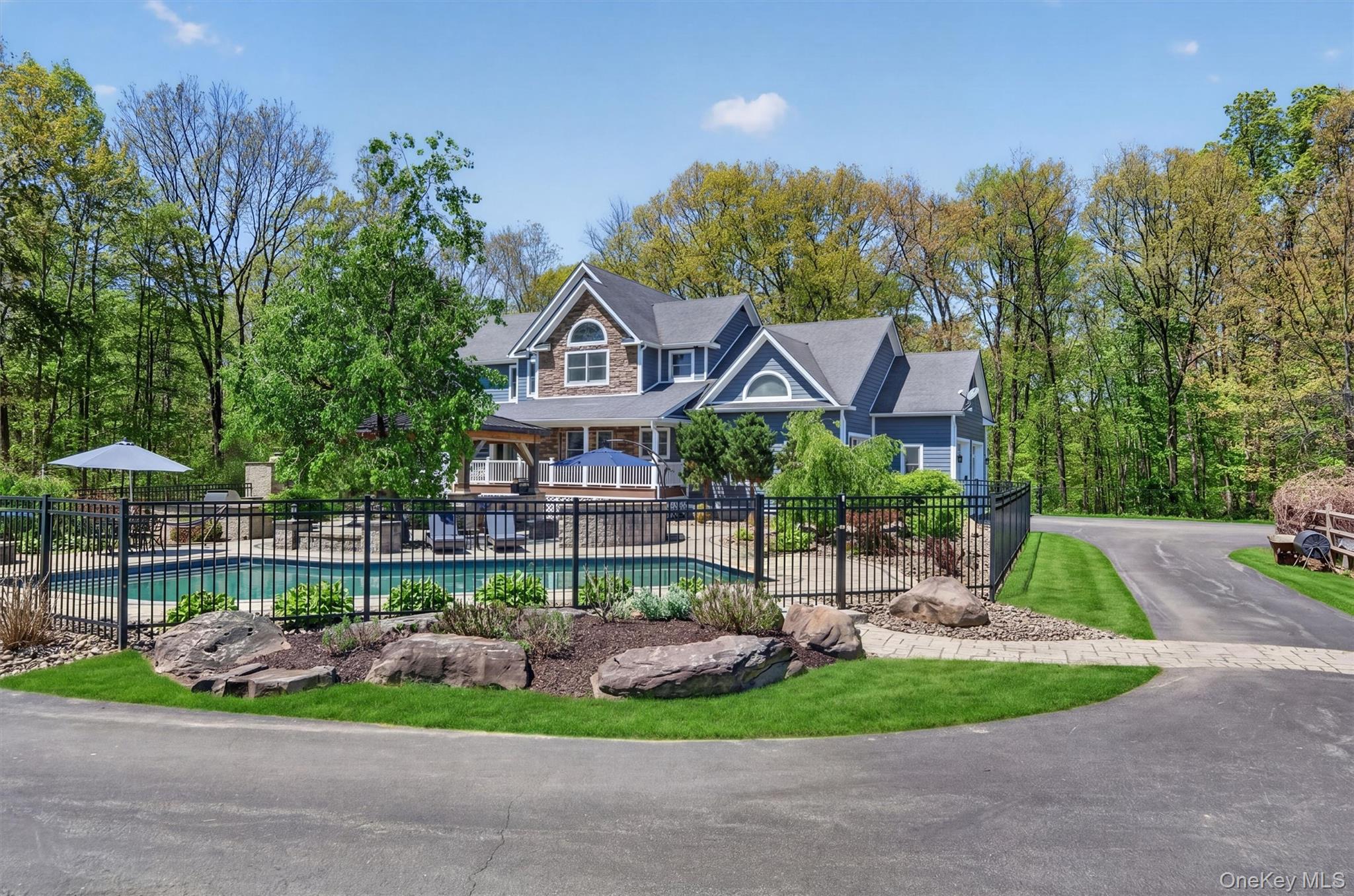 2 White Horse Road Middletown, NY 10940 - Photo 35 of 47 The sprawling, sun-drenched patio offers a vast footprint for poolside lounging and outdoor dining, perfect for hosting summer gatherings on a grand scale.