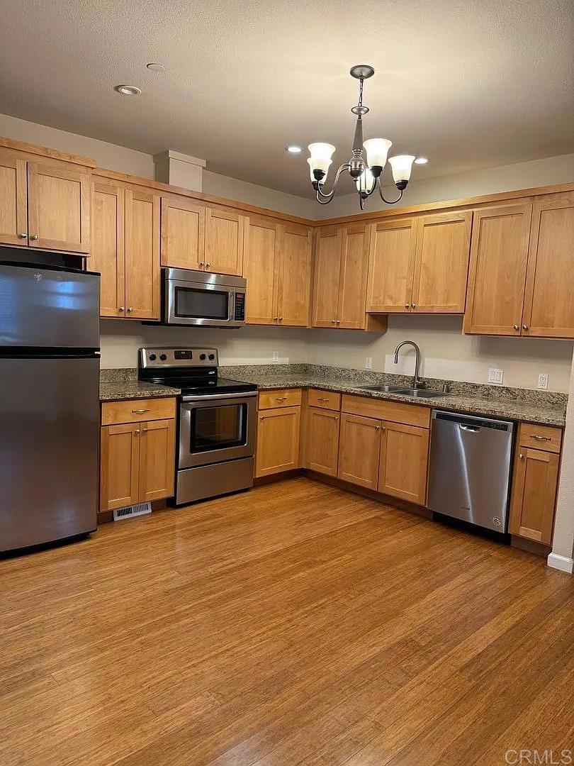 3615 Chestnut Street Lafayette, CA 94549 - Photo 3 of 11 a kitchen with stainless steel appliances granite countertop a sink a stove a refrigerator cabinets and wooden floor
