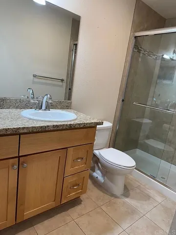 a bathroom with a granite countertop sink toilet and shower