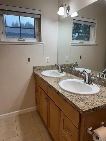 a bathroom with a granite countertop sink and a mirror