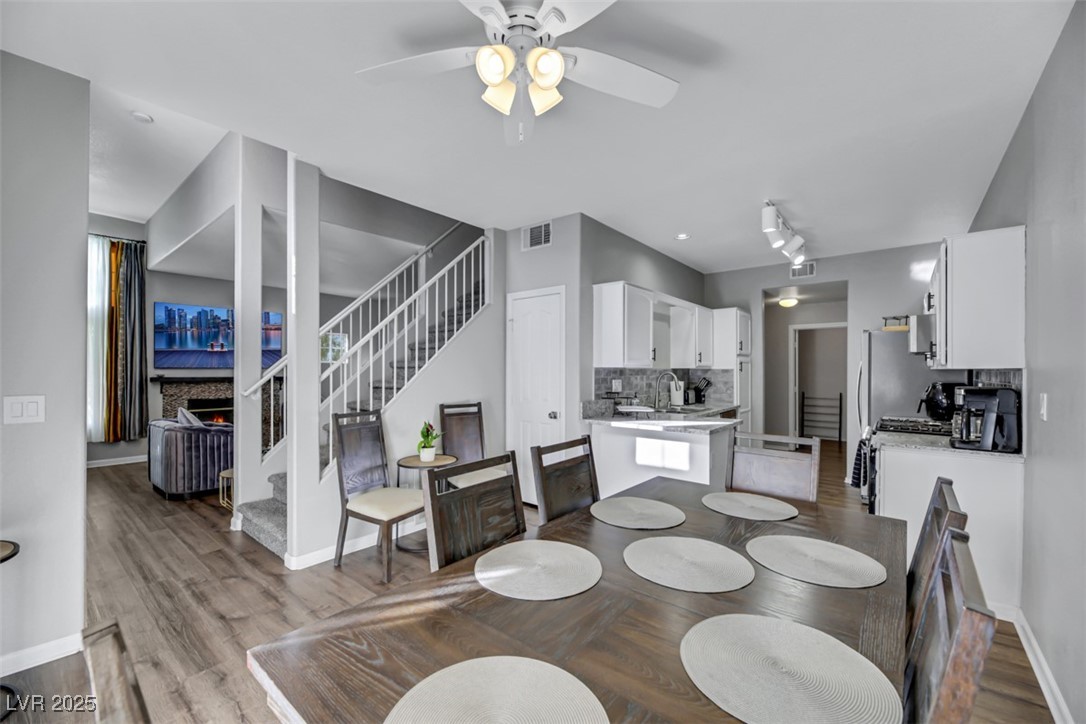 2907 Rio Sonora Court Henderson, NV 89074 - Photo 11 of 35 Dining room with stairway, light wood-type flooring, a ceiling fan, and a fireplace
