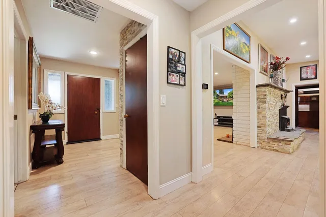 a view of a hallway with wooden floor and windows