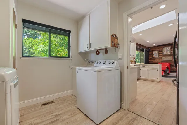 a utility room with cabinets washer and dryer