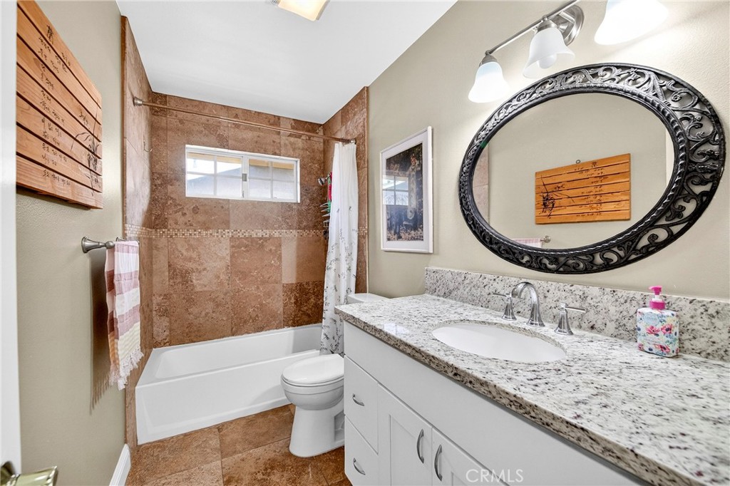 15243 Crosswood Road La Mirada, CA 90638 - Photo 15 of 44 a bathroom with a granite countertop toilet a sink and a mirror