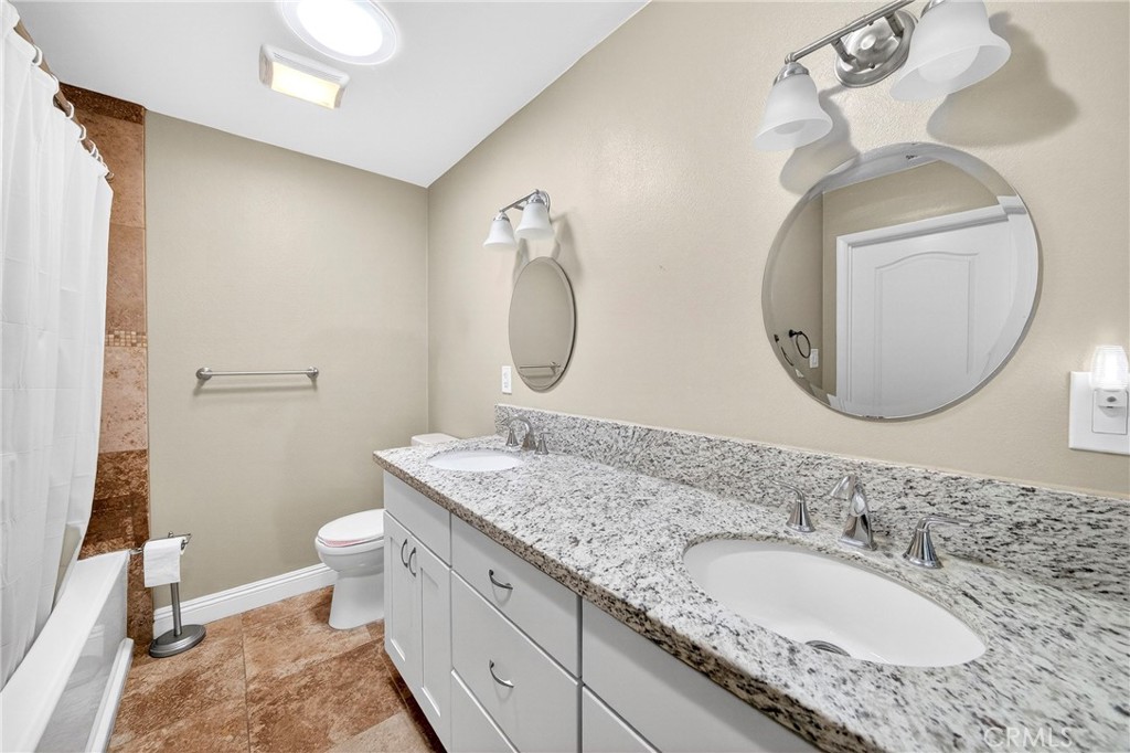 15243 Crosswood Road La Mirada, CA 90638 - Photo 20 of 44 a bathroom with a granite countertop double vanity sink mirror and toilet