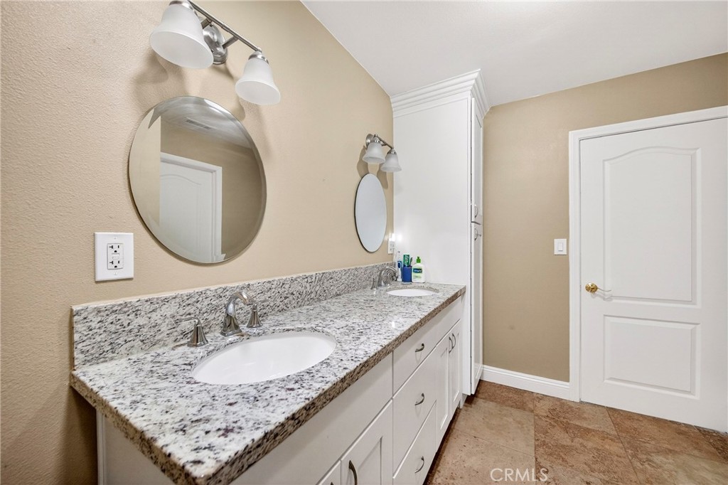 15243 Crosswood Road La Mirada, CA 90638 - Photo 21 of 44 a bathroom with a granite countertop double vanity sink and a mirror