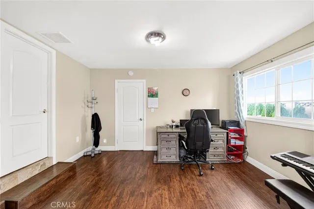 a view of a workspace with furniture and a window