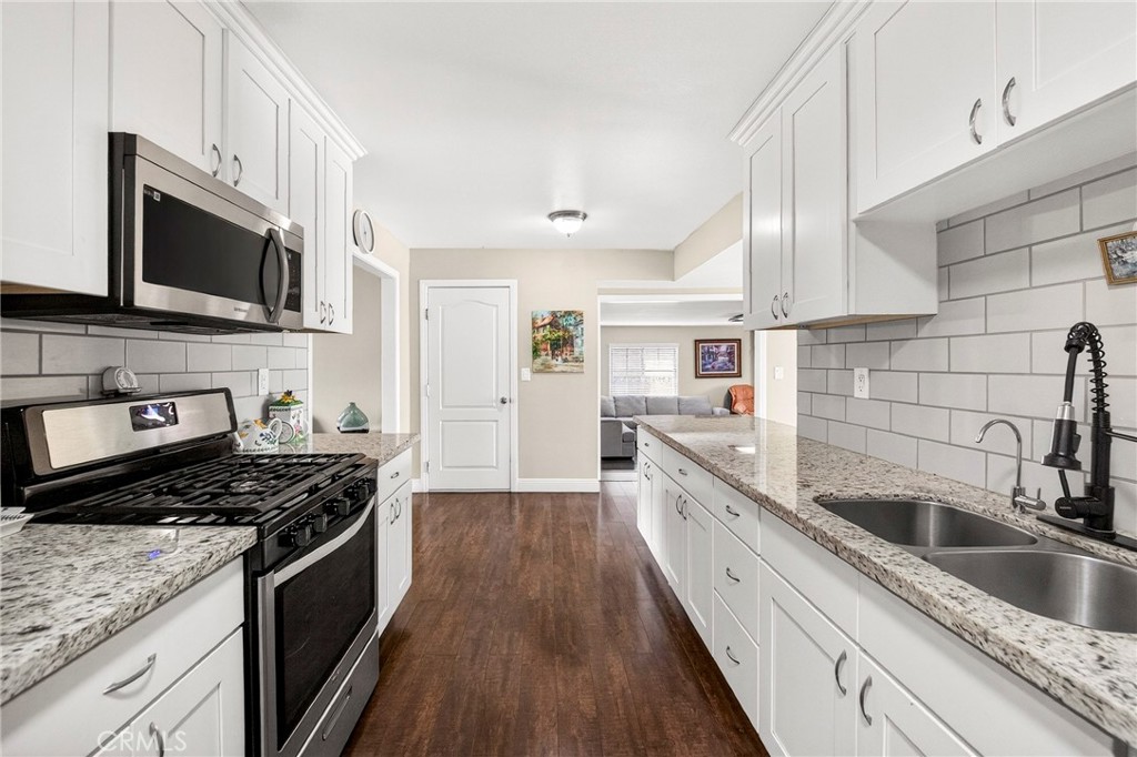 15243 Crosswood Road La Mirada, CA 90638 - Photo 29 of 44 a kitchen with stainless steel appliances granite countertop a sink a stove top oven and wooden floors