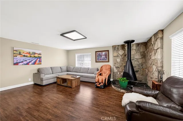 a living room with furniture two window and a wooden floor