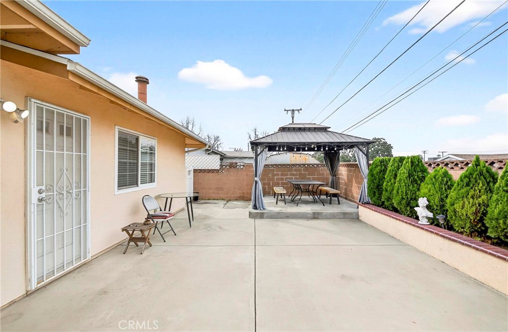 15243 Crosswood Road La Mirada, CA 90638 - Photo 44 of 44 a view of a patio with table and chairs under an umbrella with a small yard