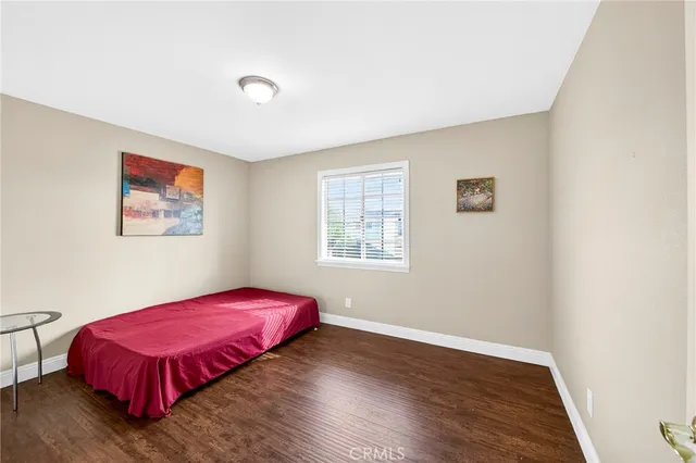 a view of a bedroom with wooden floor and a window
