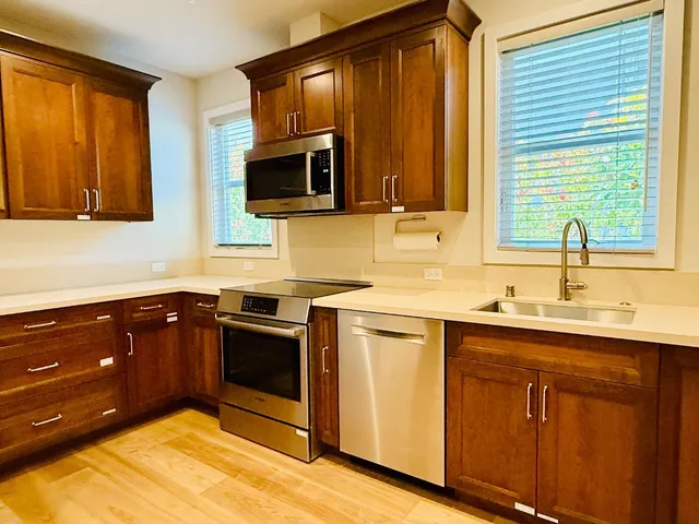 a kitchen with stainless steel appliances granite countertop a sink stove and microwave
