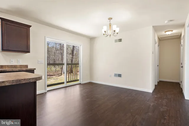 a view of an empty room with a kitchen