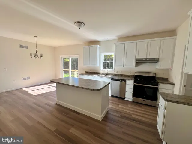 a kitchen with granite countertop a sink cabinets and stainless steel appliances