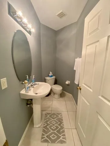 a bathroom with a sink a toilet and mirror