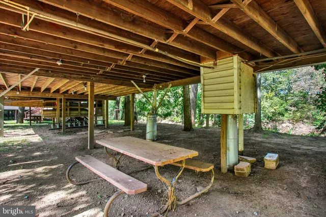 a view of a patio with table and chairs a barbeque with wooden floor and roof with potted plants