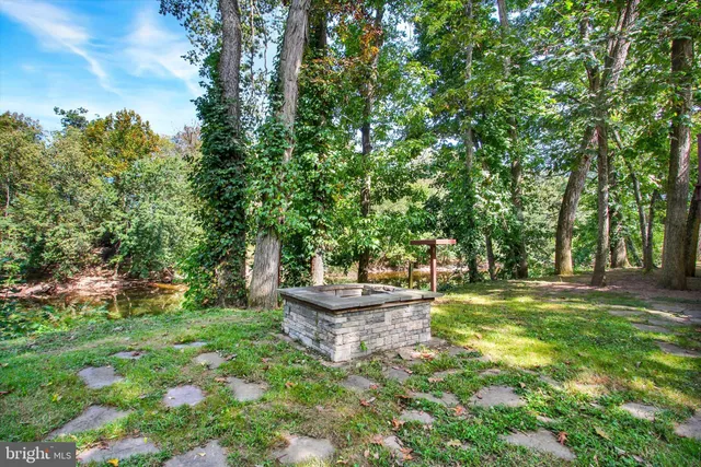 a backyard of a house with fountain table and chairs