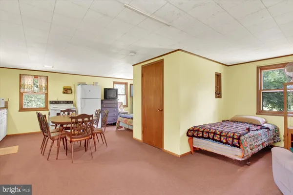 a bedroom with a bed and large windows