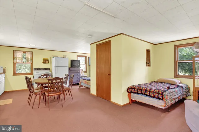 a bedroom with a bed and large windows