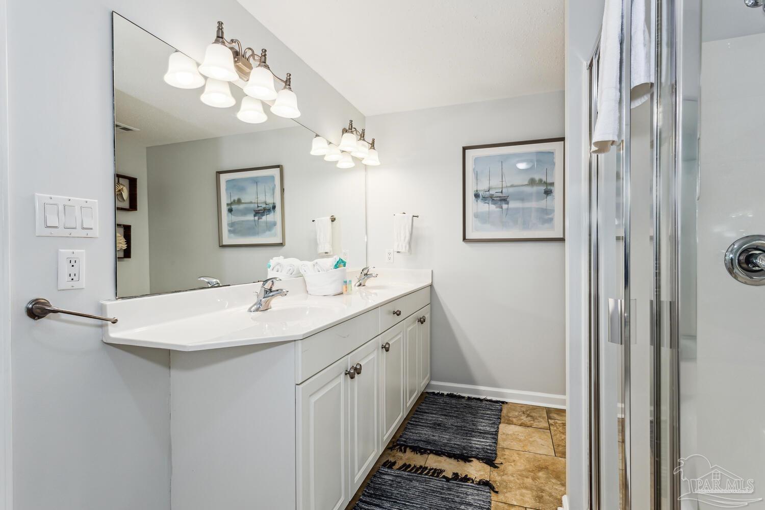 14511 Perdido Key Drive, Unit 1303 Perdido Key, FL 32507 - Photo 21 of 58 a bathroom with a double vanity sink a mirror and a shower