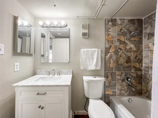 a bathroom with a sink toilet vanity and shower