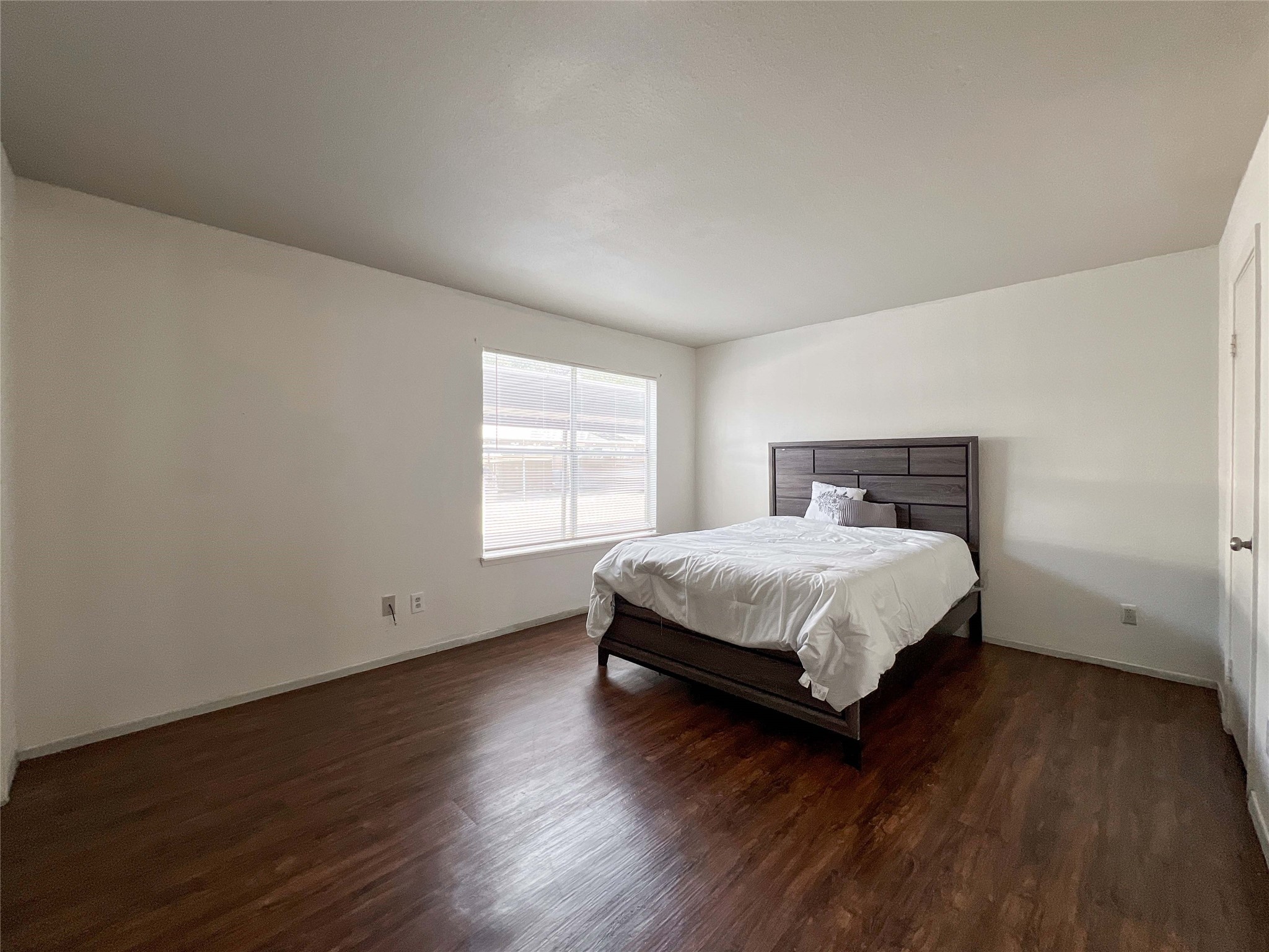 6001 Reims Road, Unit 1207 Houston, TX 77036 - Photo 8 of 18 a bedroom with a bed and wooden floor