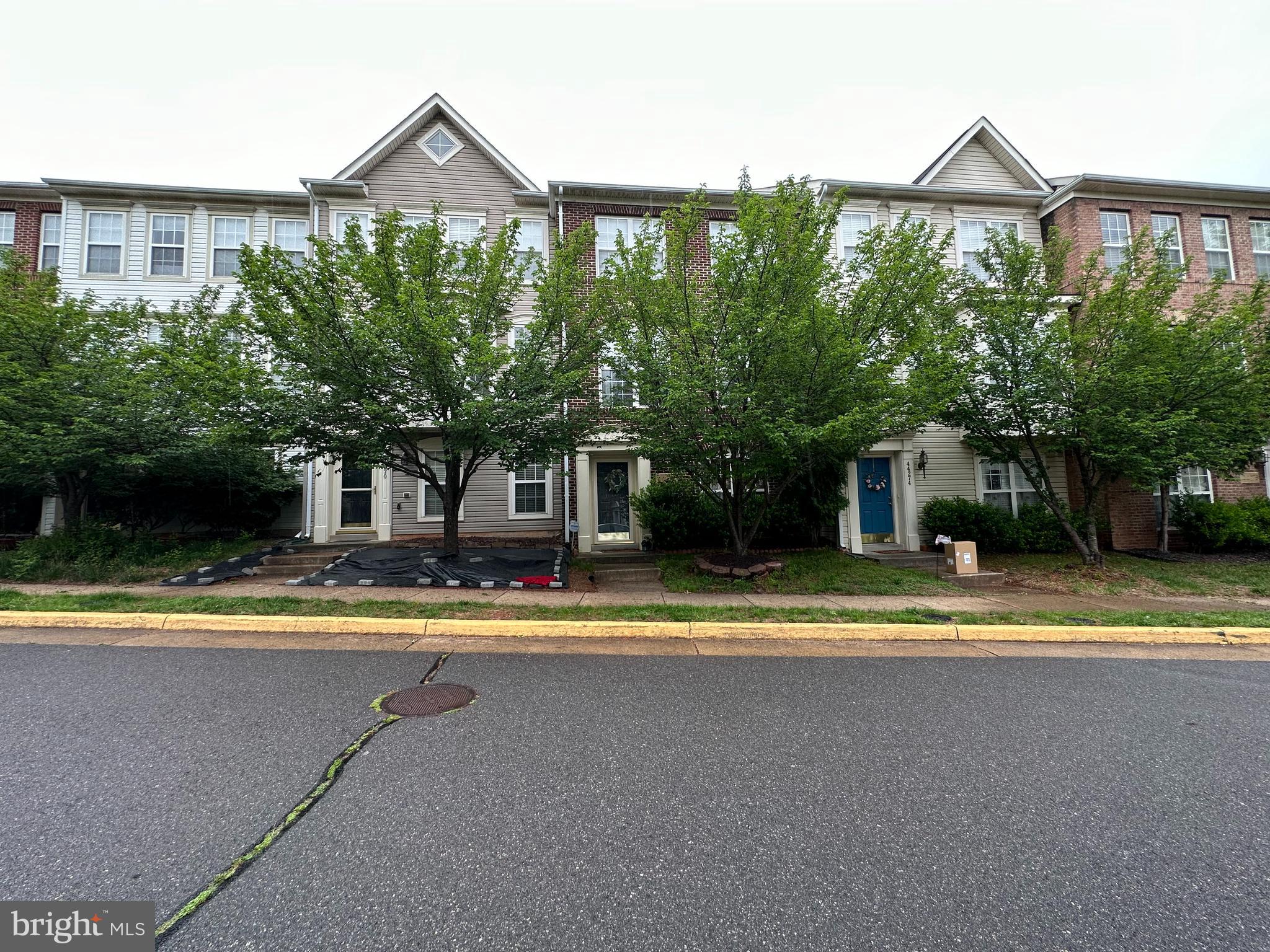 a view of a house with a yard and large tree