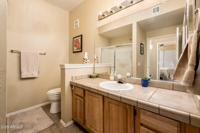 a bathroom with a granite countertop sink mirror and a toilet