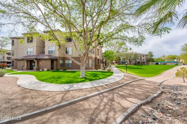 a view of a house with a big yard and large trees