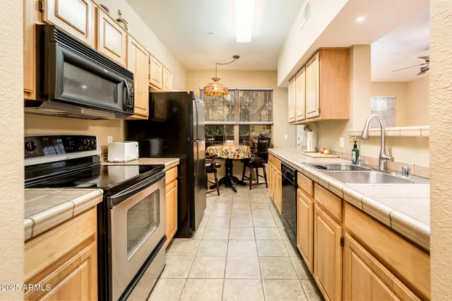 a kitchen with stainless steel appliances granite countertop a stove top oven a sink dishwasher and a microwave oven with cabinets